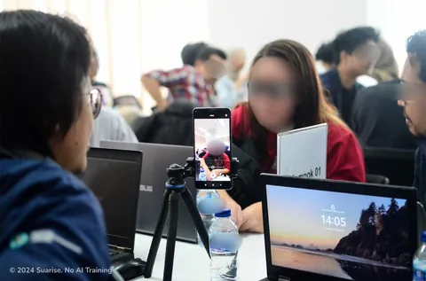 Sesi pengujian pengguna: ponsel di tripod merekam peserta yang duduk di seberang meja